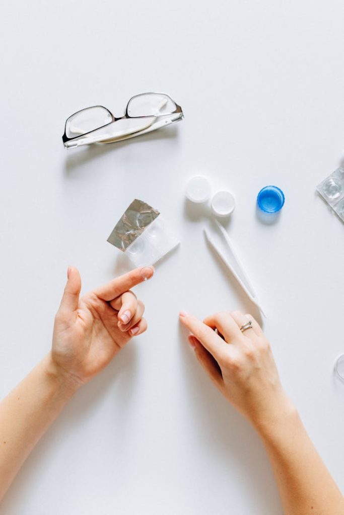 pexels photo 5842837 Flatlay of contact lens supplies with glasses and hands, ideal for vision care themes.